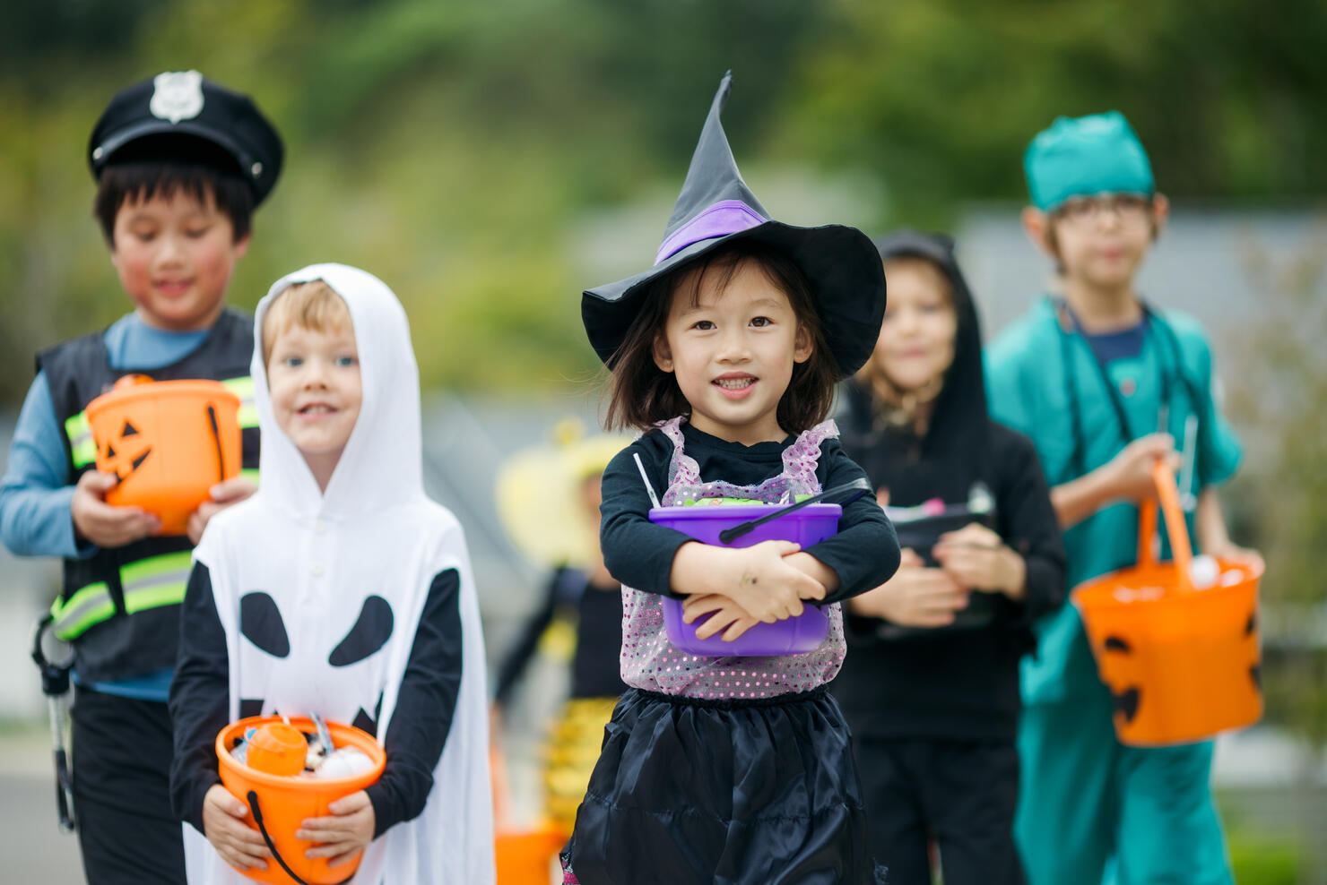 Children Trick Or Treat For Halloween In Residential Neighborhood