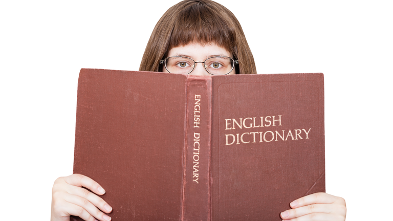 girl looks over English Dictionary book isolated