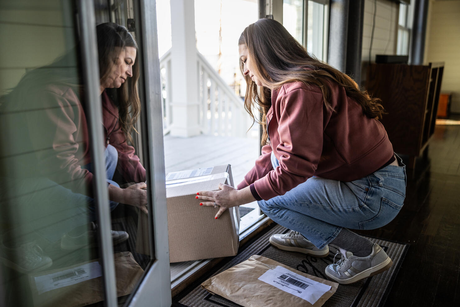 Woman picking up delivery packages on her doorstep