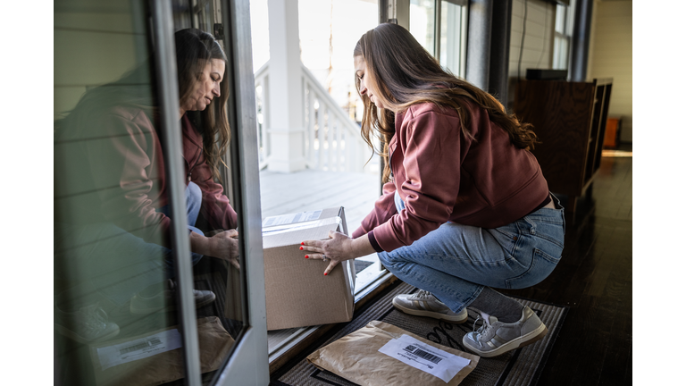 Woman picking up delivery packages on her doorstep