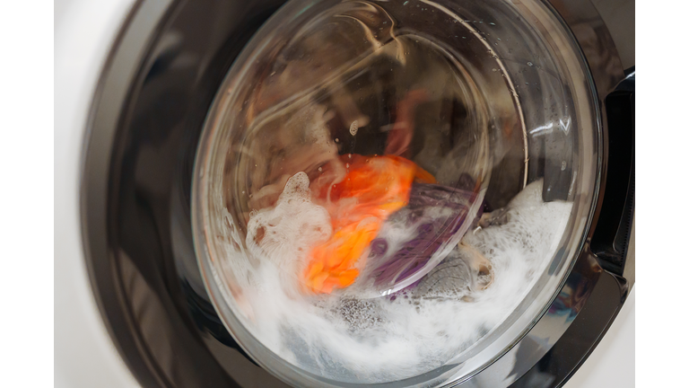 Closeup of washing machine door with spinning laundry