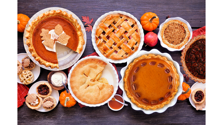 Homemade autumn pie table scene. Overhead view on a dark wood background.