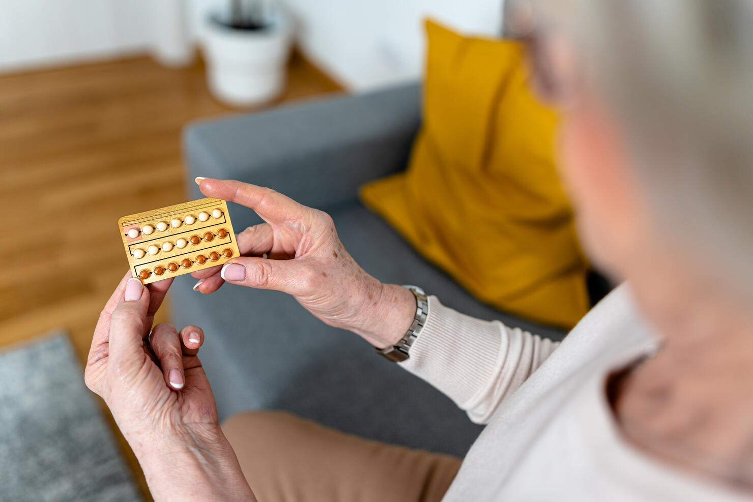 A close-up photo of a woman using pills for controlling hormones during menopause.