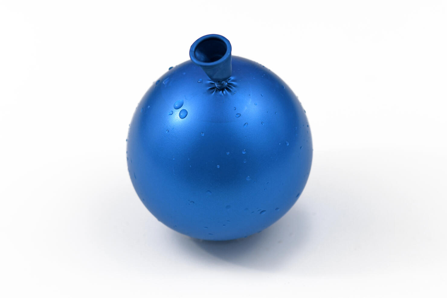 Small blue water bomb, balloon filled with water, isolated on white background