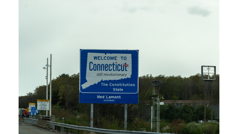 Welcome to Connecticut sign on a gray cloudy day with road construction signs