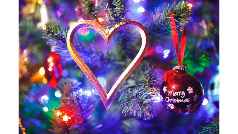 Christmas tree with heart shape decoration and purple illumination