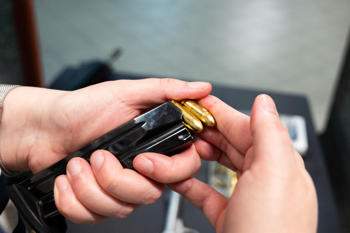 woman hands loading pistol magazine with bullets