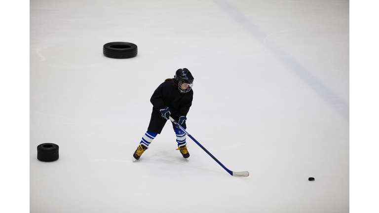 Girl hockey player on the hockey arena