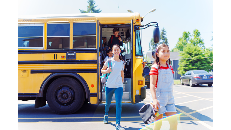 Teenage girl getting off school bus