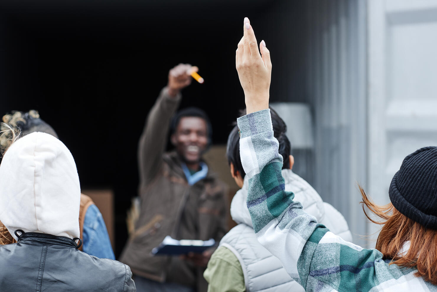 Close up of young woman raising hand at outdoor auction