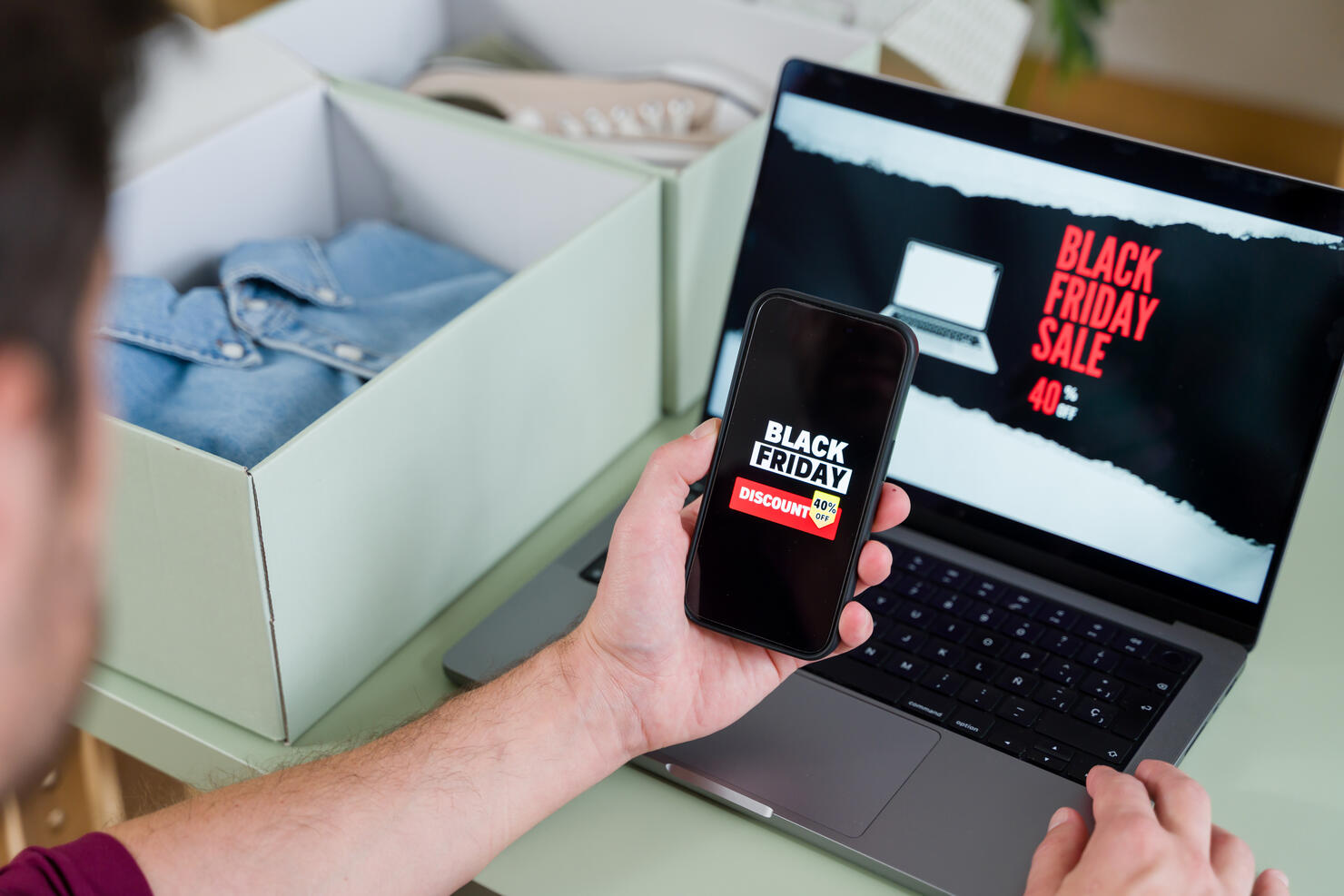 Man shopping online during black friday using laptop and smartphone