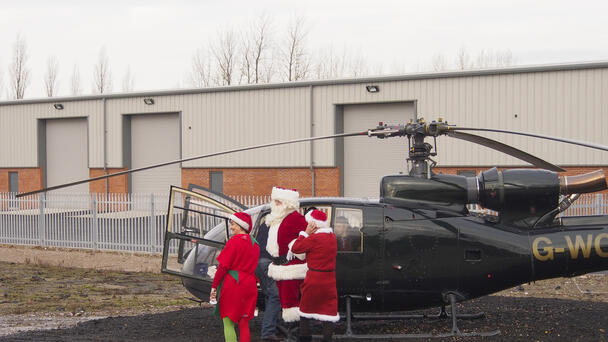 Helicopter Transporting Santa Aborts Landing After Getting Hit By Debris