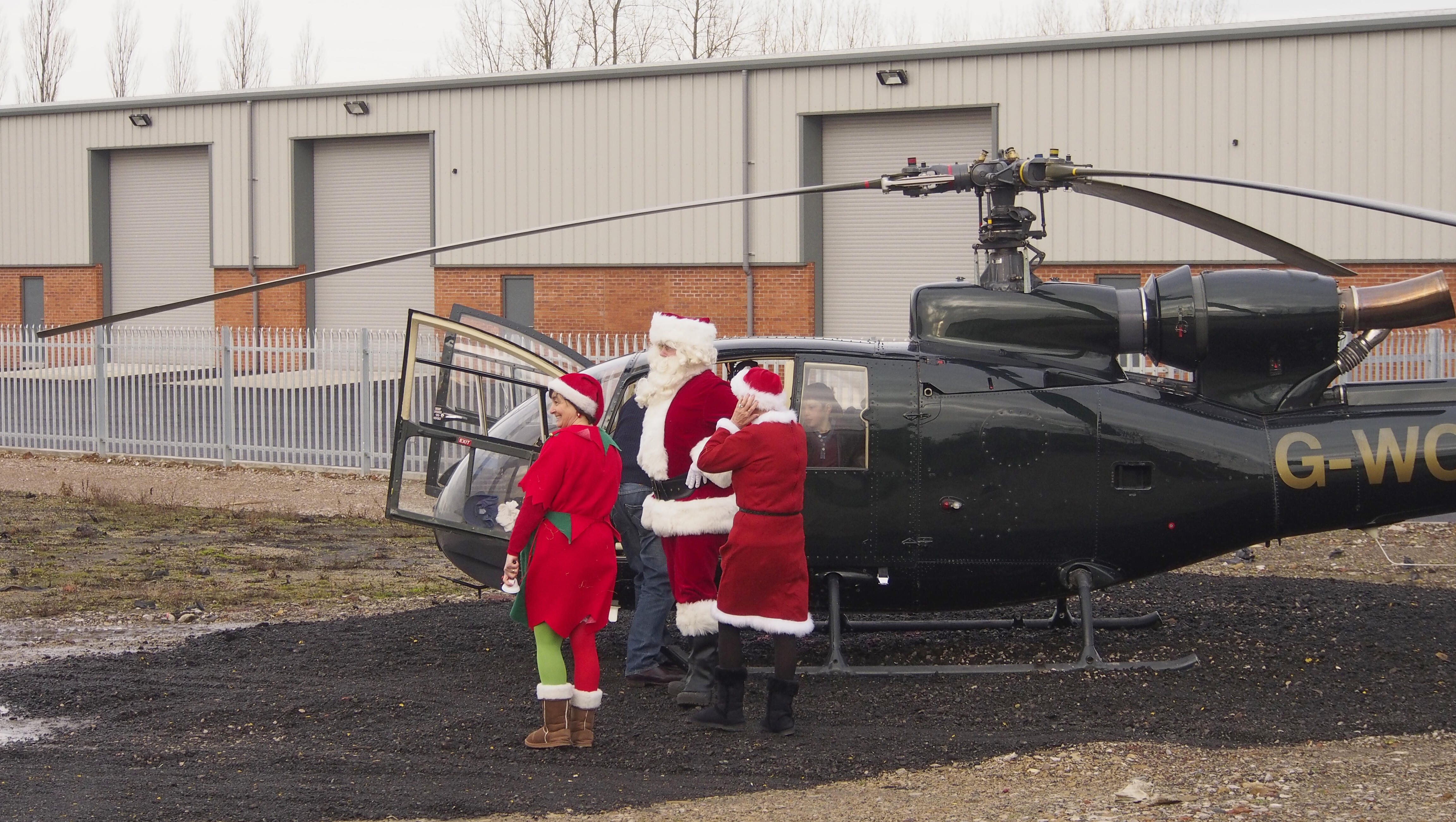 Helicopter Transporting Santa Aborts Landing After Getting Hit By Debris