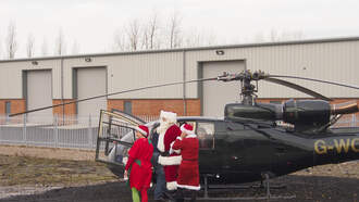 Helicopter Transporting Santa Aborts Landing After Getting Hit By Debris