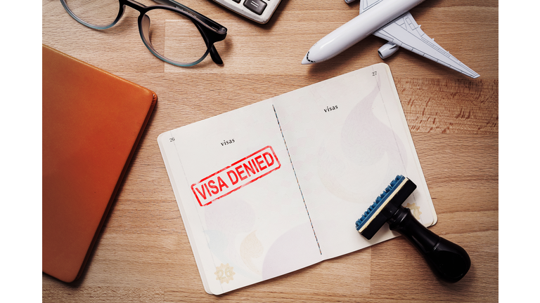 visa and passport with denied stamp on a document top view in immigration. travel immigration stamp and tourism concept