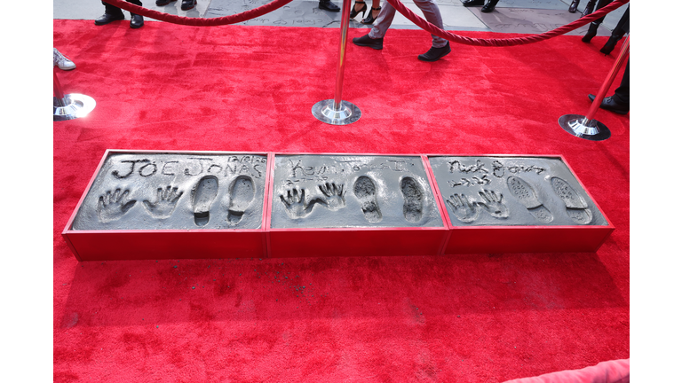Jonas Brothers Hand And Footprint In Cement Ceremony At TCL Chinese Theater