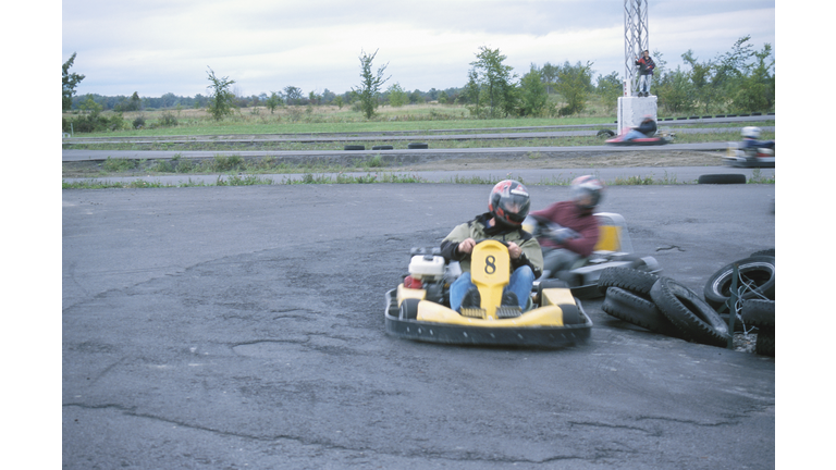 People driving around tires in go-cart