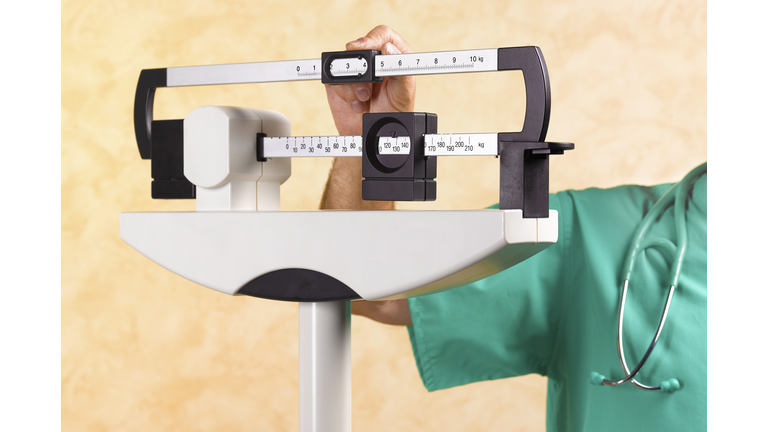 DR WITH OVERWEIGHT PATIENT ON MEDICAL SCALES