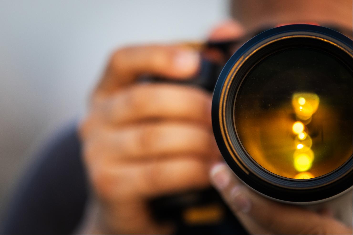 A man is taking a photo at sunset.