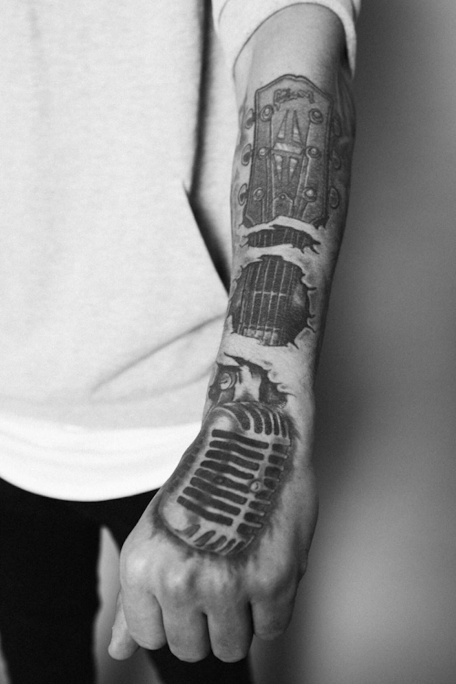 Microphone and Guitar Neck Tattoo on Kane Brown's Left Forearm and Hand