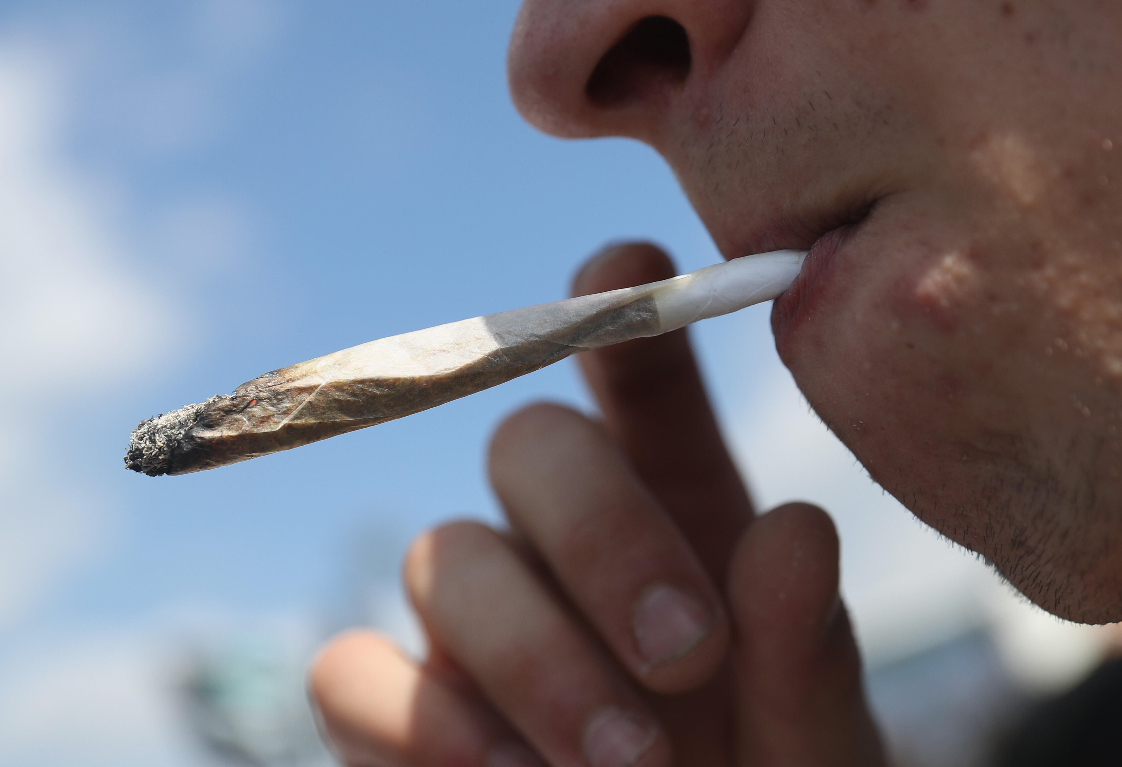 BERLIN, GERMANY - AUGUST 13:  An activists smokes a marijuana joint prior to marching in the annual Hemp Parade (Hanfparade) on August 13, 2016 in Berlin, Germany. German proponents of cannabis legalization are hoping that the legalization in several stat