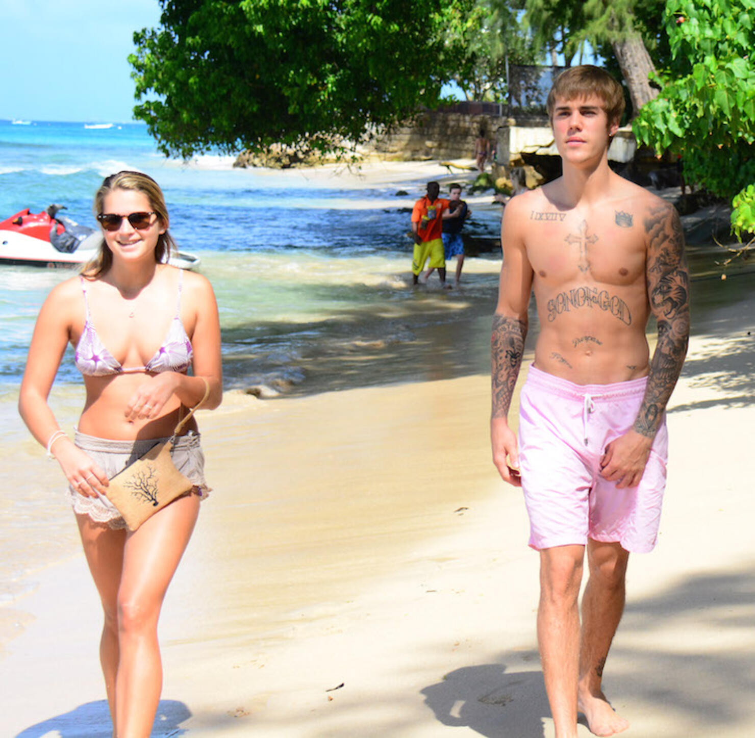A shirtless Justin Bieber  delighted some bikini clad  with fans on the beach in Barbados.