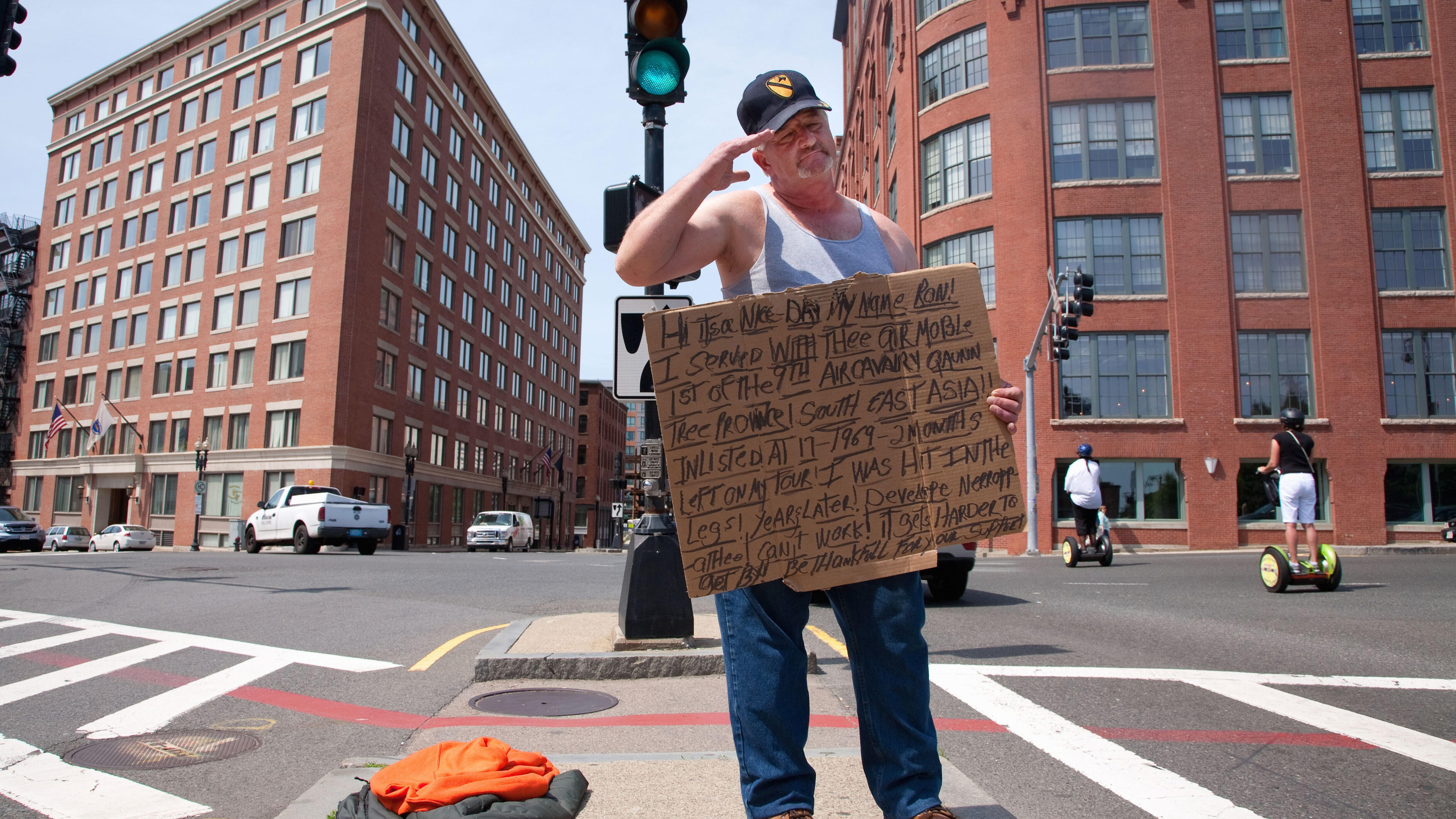 Vietnam War veteran salutes passerbys as he panhandles for money on streets of Boston, MA. (Photo by: VOA/UIG via Getty Images)