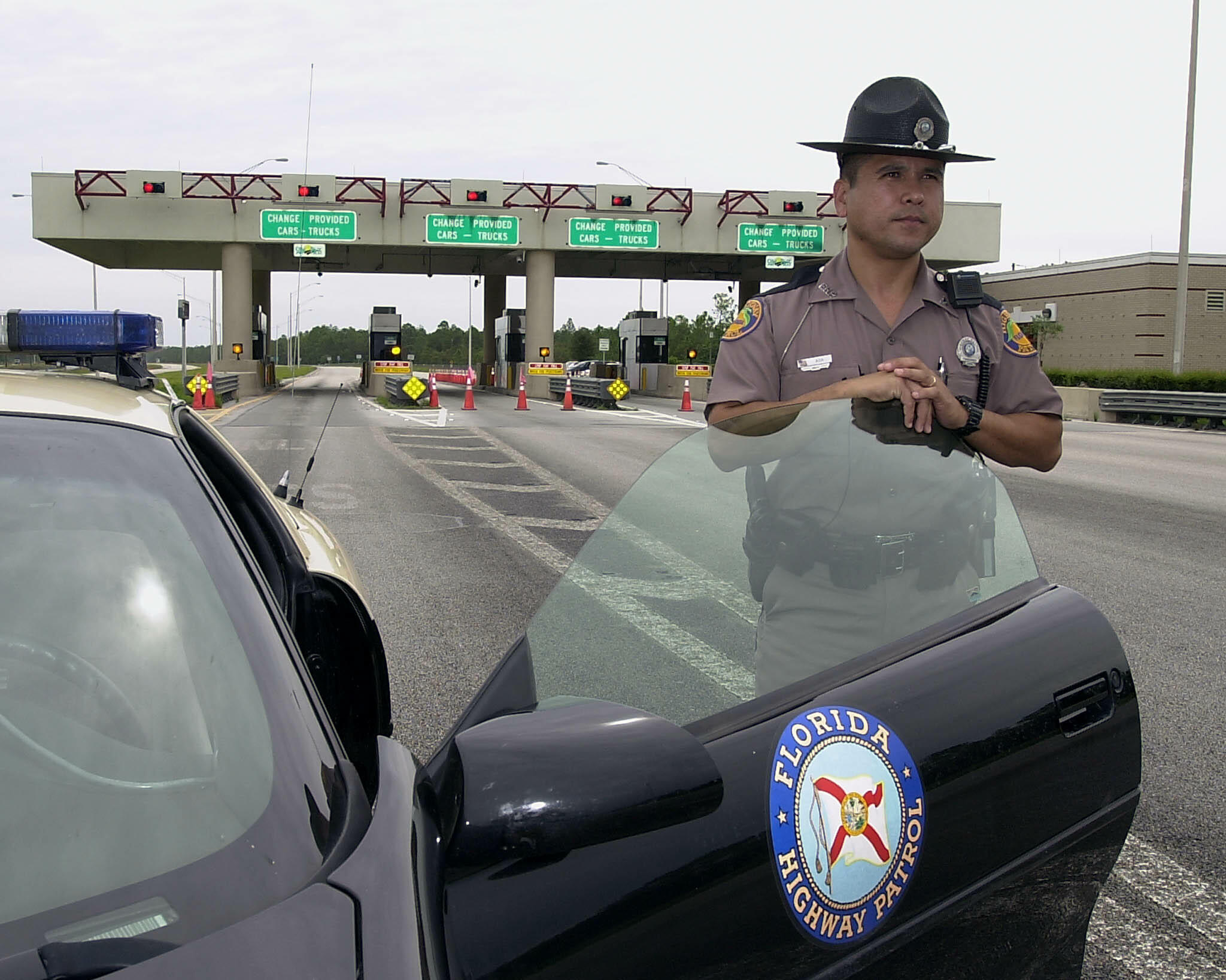 NAPLES, :  Florida Highway Patrol Officer Ray Ada stands guard at the closed Edward J. Beck toll plaza 13 September 2002 during the search of two isolated vehicles belonging to three men in suspicion of plotting an explosives attack located on I-75 in sou