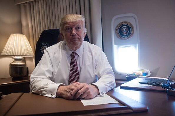 US President Donald Trump poses in his office aboard Air Force One at Andrews Air Force Base in Maryland after he returned from Philadelphia on January 26, 2017. / AFP / NICHOLAS KAMM        (Photo credit should read NICHOLAS KAMM/AFP/Getty Images)