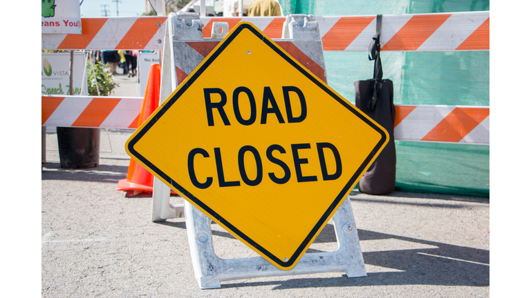 Road Closed Sign with Barricade in Background