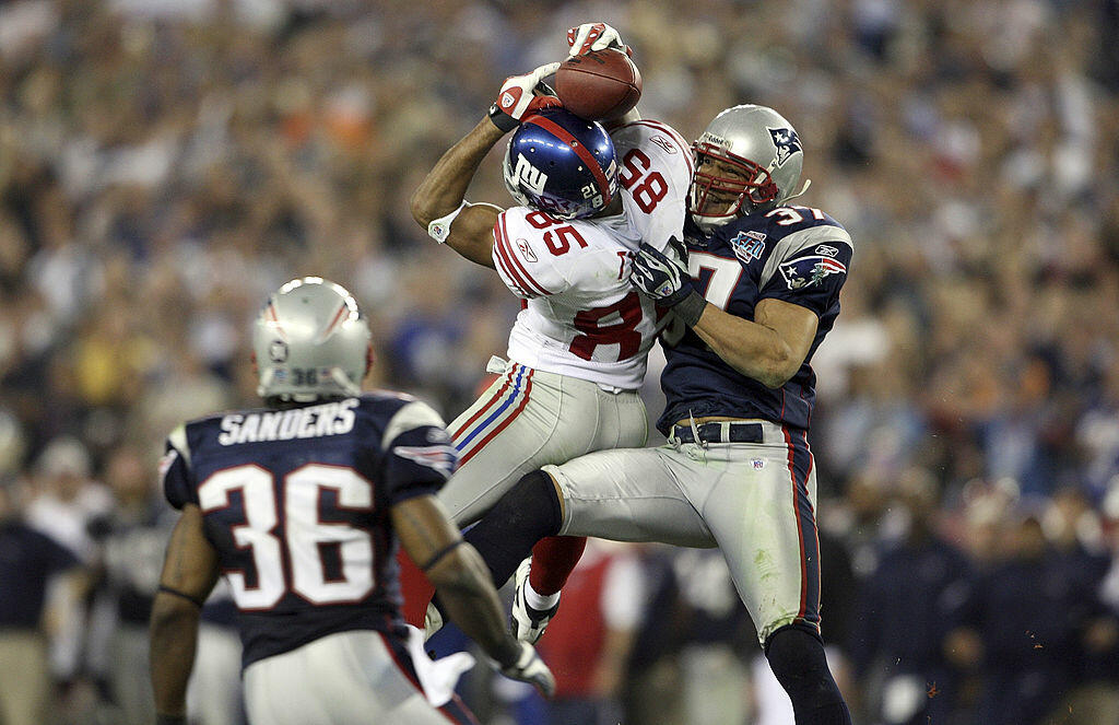 GLENDALE, AZ - FEBRUARY 03:  David Tyree #85 of the New York Giants catches a 32-yard pass from Eli Manning #10 against Rodney Harrison #37 and James Sanders #36 of the New England Patriots attempts to knock it out in the fourth quarter of Super Bowl XLII