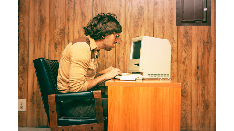 Funny Nerdy Man Looking Intensely at Vintage Computer