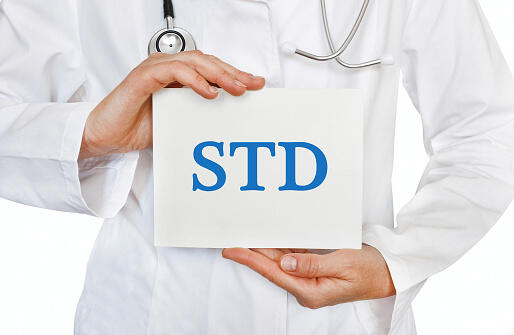 Doctor holding a card with STD, medical concept