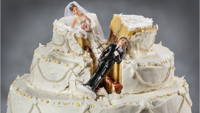Bride and groom figurines collapsed at ruined wedding cake