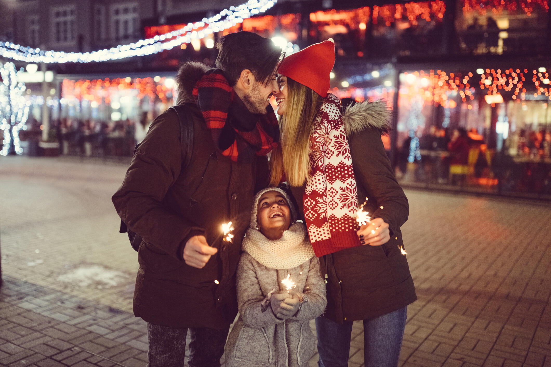 Young family with daughter celebrating New Year in the city