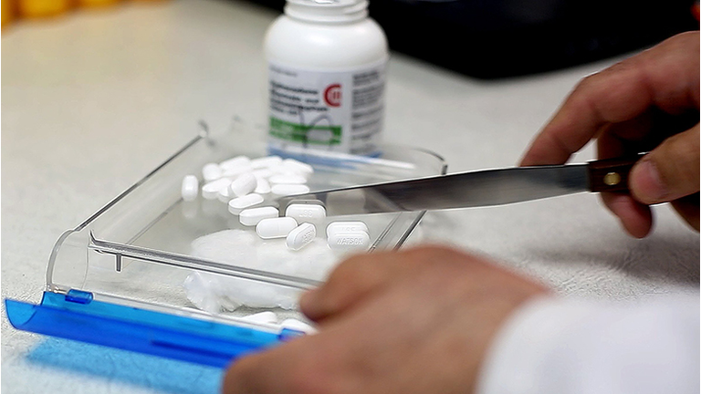 A pharmacist counts pain medication at a South Portland Pharmacy Thursday, Feb. 19, 2014. With the s