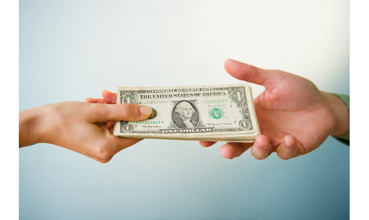 Close up of man's and woman's hands holding banknotes, studio shot