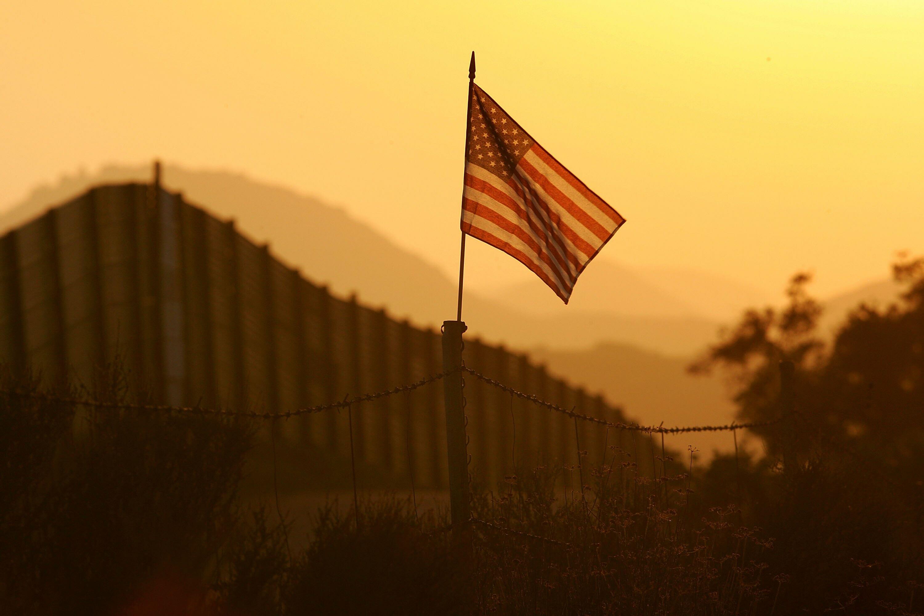 CAMPO, CA - OCTOBER 08:  A U.S. flag put up by activists who oppose illegal immigration flies near the US-Mexico border fence in an area where they search for border crossers October 8, 2006 near Campo, California. The activists want the fence expanded in