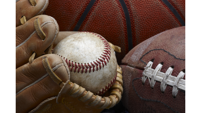 Dirty old baseball, glove, football and basketball
