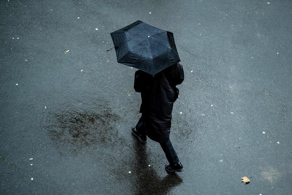 A man with an umbrella walks in the rain in Duesseldorf, western Germany, on February 7, 2017. / AFP / dpa / Federico Gambarini / Germany OUT        (Photo credit should read FEDERICO GAMBARINI/AFP/Getty Images)