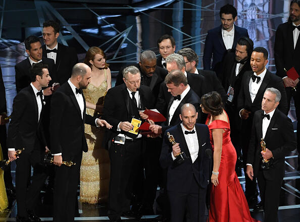 HOLLYWOOD, CA - FEBRUARY 26:  'La La Land' producer Fred Berger (R) speaks at the microphone as production staff consult behind him regarding a presentation error of the Best Picture award (later awarded to 'Moonlight') onstage during the 89th Annual Academy Awards at Hollywood & Highland Center on February 26, 2017 in Hollywood, California.  (Photo by Kevin Winter/Getty Images)