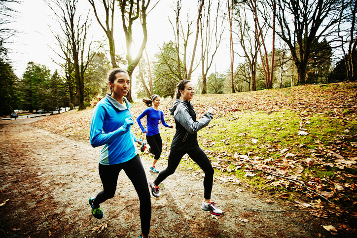 Friends running trails together on winter morning