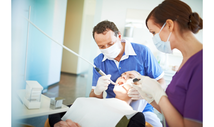 Dentist operating on a patient in pain