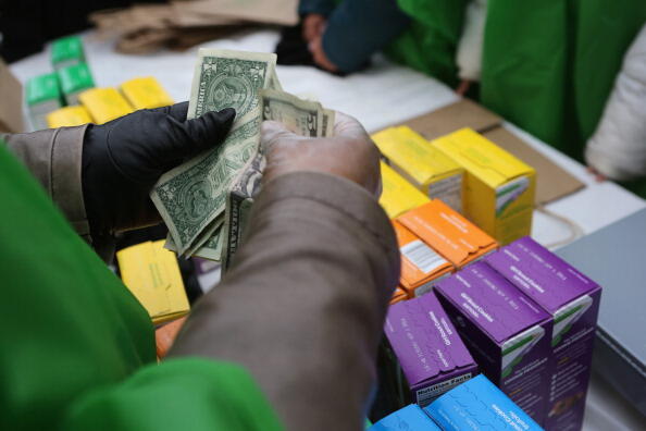 NEW YORK, NY - FEBRUARY 08:  MOney is collected as Girl Scouts sell cookies while a winter storm moves in on February 8, 2013 in New York City. The scouts did brisk business, setting up shop in locations around Midtown Manhattan on National Girl Scout Coo