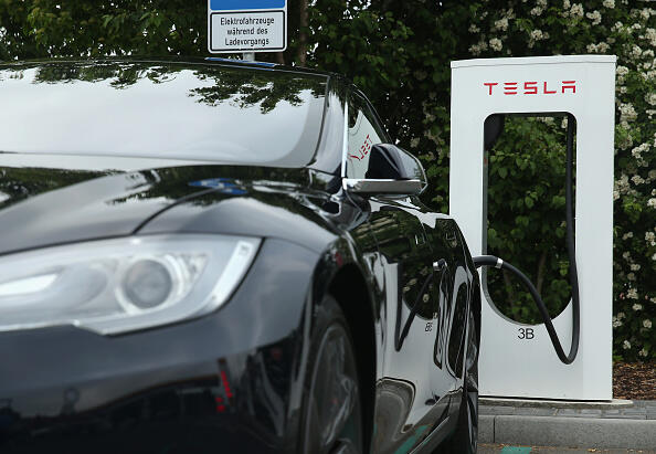 RIEDEN, GERMANY - JUNE 11:  A Tesla electric-powered sedan stands at a Tesla charging staiton at a highway reststop along the A7 highway on June 11, 2015 near Rieden, Germany. Tesla has introduced a limited network of charging stations along the German highway grid in an effort to raise the viability for consumers to use the cars for longer journeys.    (Photo by Sean Gallup/Getty Images)