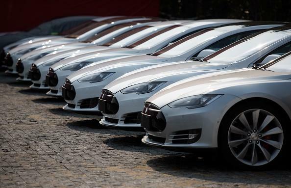 To go with AFP story China-auto-show-environment-Tesla,FOCUS by Bill Savadove This picture taken on  March 17, 2015 shows Tesla Model S vehicles parked outside a car dealership in Shanghai. Serial entrepreneur Elon Musk has launched spacecraft into orbit, but popularising his Tesla electric cars in China is proving to be tougher than rocket science. AFP PHOTO / JOHANNES EISELE        (Photo credit should read JOHANNES EISELE/AFP/Getty Images)