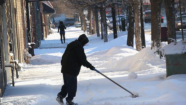 CHICAGO, IL - JANUARY 21: A resident clears snow from a sidwalk in the Humboldt Park neighborhood on January 21, 2014 in Chicago, Illinois. A weather system moved through the area overnight dumping from 6 to 12 inches of lake-effect snow on Chicago  and i