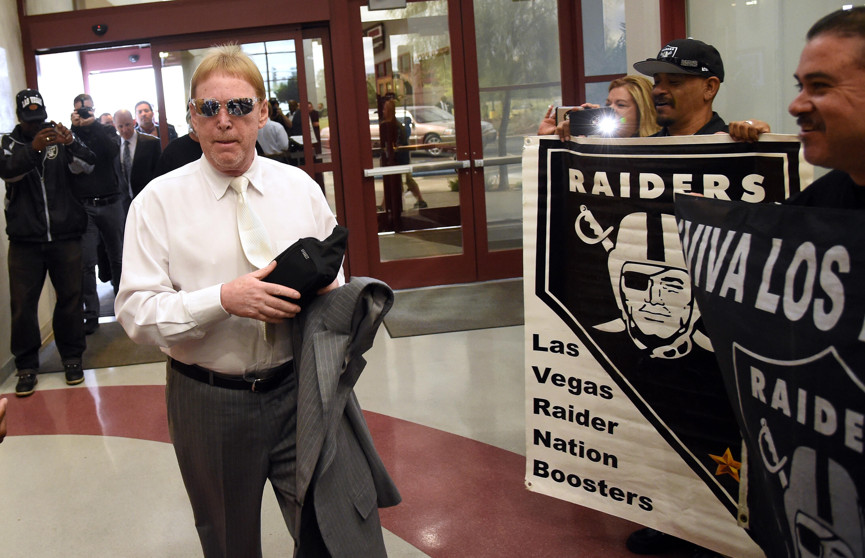 LAS VEGAS, NV - APRIL 28:  Oakland Raiders owner Mark Davis walks past fans holding Raiders signs as he arrives at a Southern Nevada Tourism Infrastructure Committee meeting at UNLV on April 28, 2016 in Las Vegas, Nevada. Davis told the committee he is wi