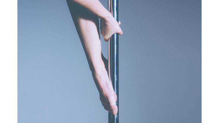 Midsection Of Pole Dancer Against Gray Background