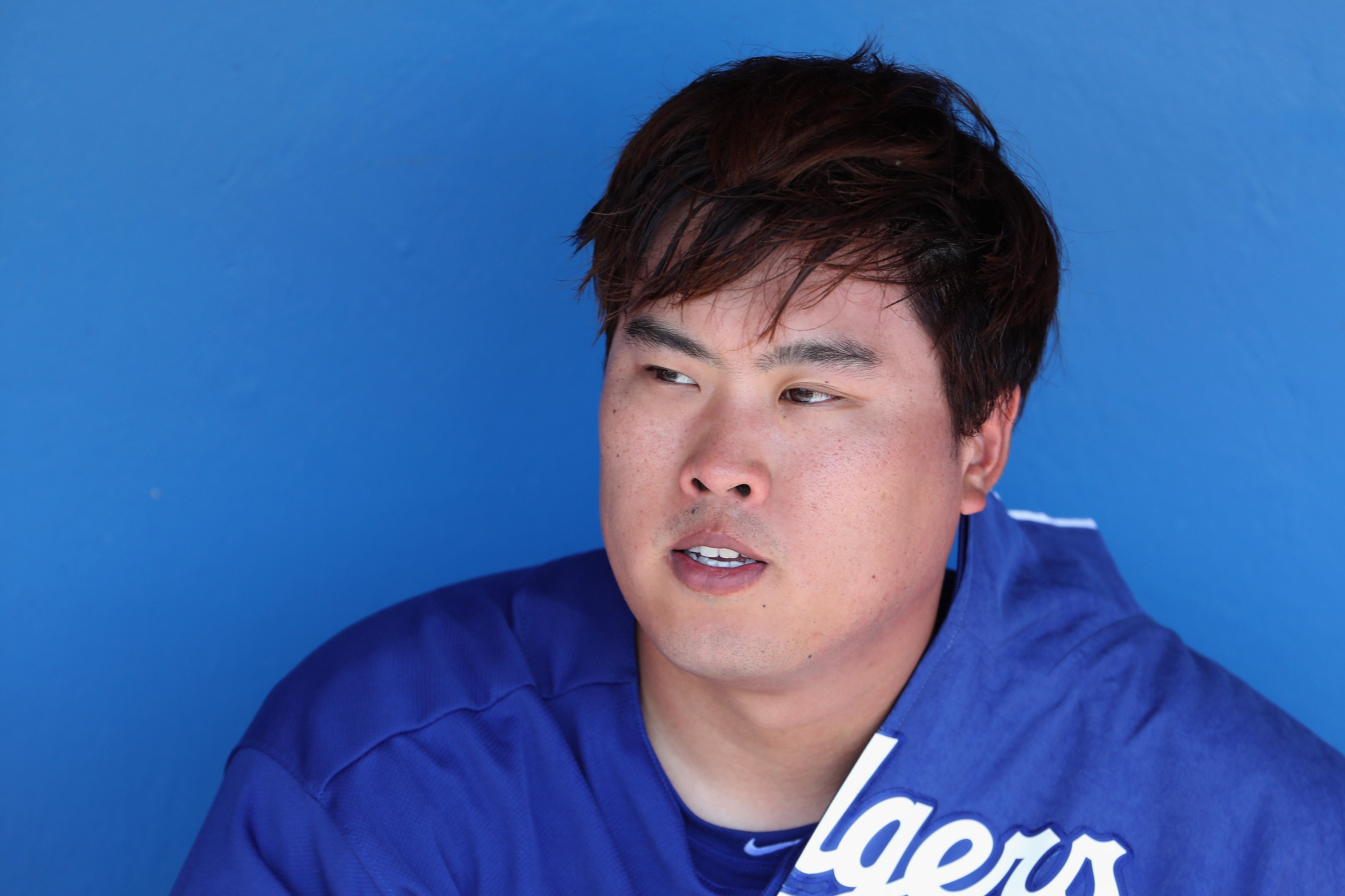 GLENDALE, AZ - MARCH 11:  Starting pitcher Hyun-Jin Ryu #99 of the Los Angeles Dodgers sits in the dugout before the spring training MLB game against the Los Angeles Angels at Camelback Ranch on March 11, 2017 in Glendale, Arizona.  (Photo by Christian Pe